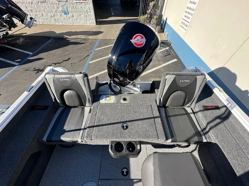 Slide: The Image of 2025 Lund 1775 Impact XS Sport boat interior with seating and motor. - 8