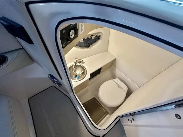 Slide: The Image of 2025 Regal LS6 boat interior bathroom with compact toilet and sink. - 18