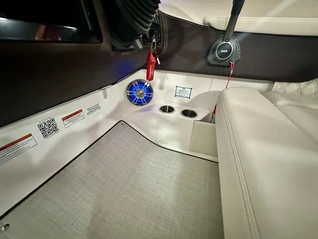 Slide: The Image of Interior of 2025 Regal LS6 boat with speaker, cup holders, and beige seating. - 21