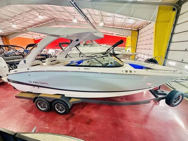 Slide: The Image of 2025 Regal LS6 boat in showroom, sleek design, on trailer. - 8