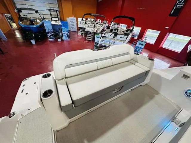 Slide: The Image of 2025 Regal 36 Grande Coupe boat interior with white seating in showroom. - 10