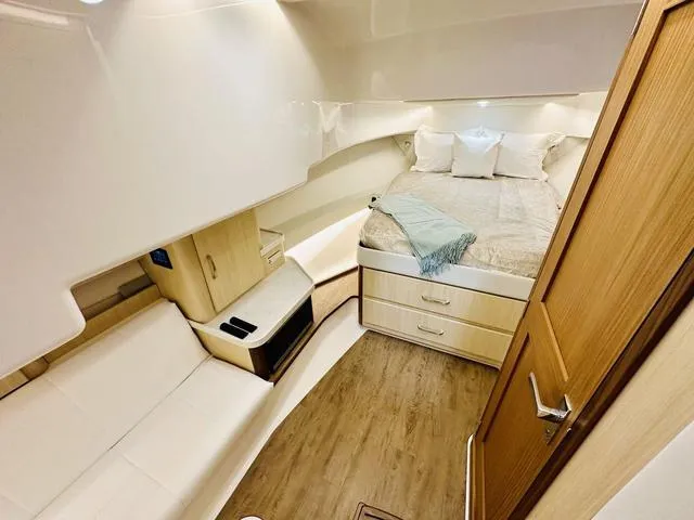 Slide: The Image of Luxurious interior of 2025 Regal 36 Grande Coupe yacht with cozy bed and seating area. - 25