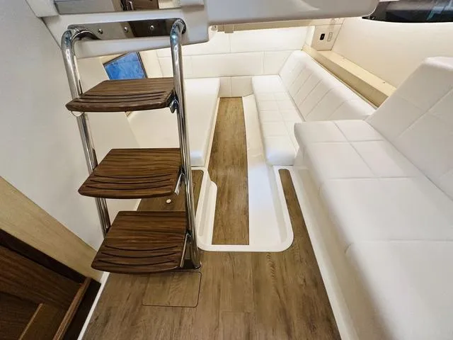 Slide: The Image of Interior of 2025 Regal 36 Grande Coupe with wooden steps and white seating. - 29