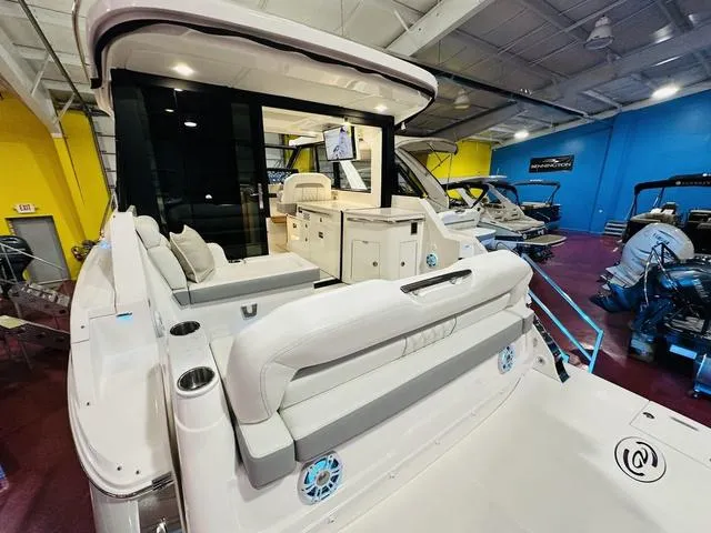 Slide: The Image of 2025 Regal 36 Grande Coupe luxury yacht interior with modern seating and entertainment system. - 4