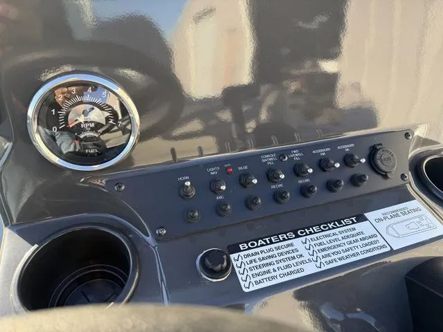 Slide: The Image of Control panel of 2025 Avid 20 ROGUE CC boat with gauges and boater's checklist. - 20