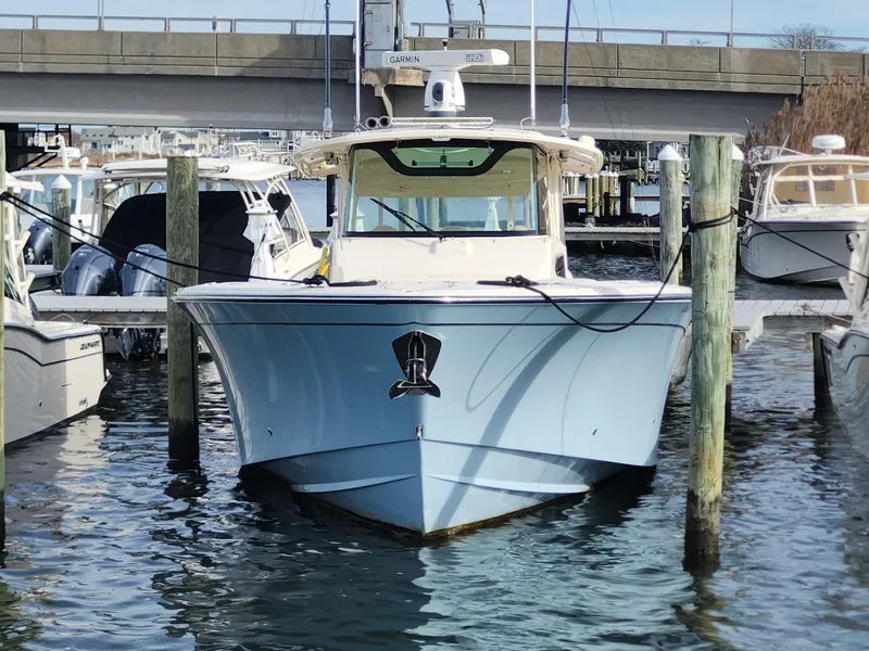 Slide: The Image of 2023 Grady-White Canyon 376 boat with triple outboard engines docked at marina. - 12