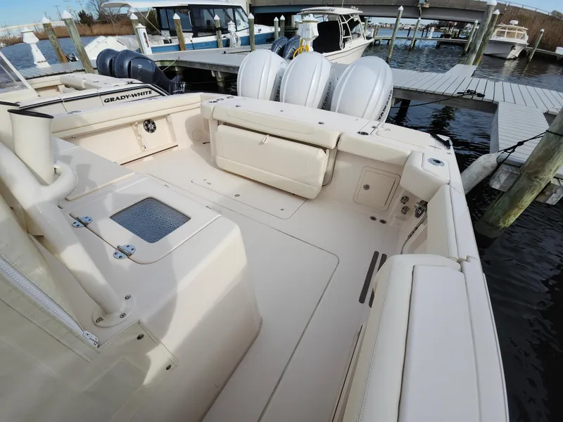 Slide: The Image of 2023 Grady-White Canyon 376 boat interior with plush seating at a marina. - 29