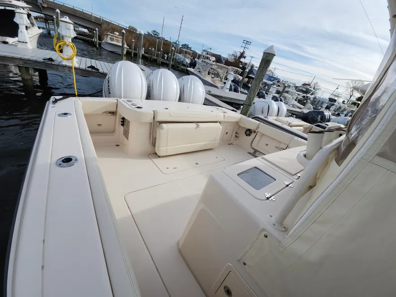 Slide: The Image of 2023 Grady-White Canyon 376 boat interior with luxurious seating at a marina. - 30