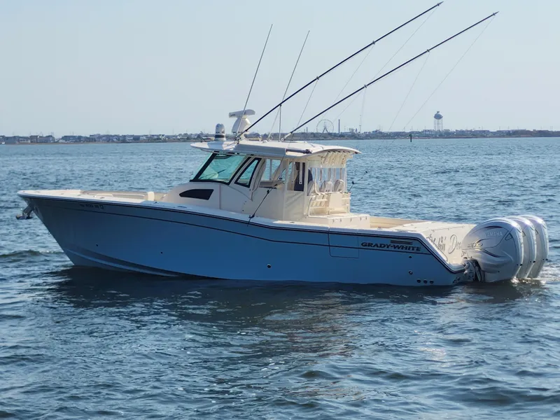 Slide: The Image of 2023 Grady-White Canyon 376 boat with triple outboard engines on open water. - 5