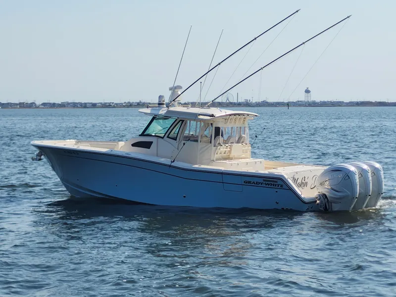 Slide: The Image of 2023 Grady-White Canyon 376 boat with triple engines cruising on open water. - 6