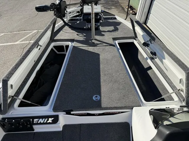 Slide: The Image of 2025 Phoenix 721 ZXL boat interior with open storage compartments and Garmin equipment. - 13