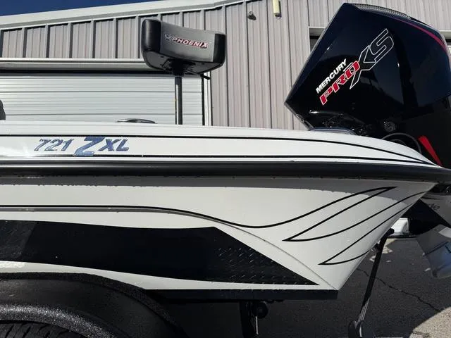 Slide: The Image of 2025 Phoenix 721 ZXL boat with Mercury Pro XS engine, parked near a metal building. - 3