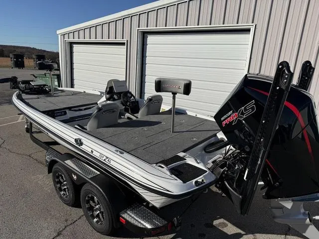 Slide: The Image of 2025 Phoenix 721 ZXL bass boat with dual seats and powerful engine, parked near storage units. - 7