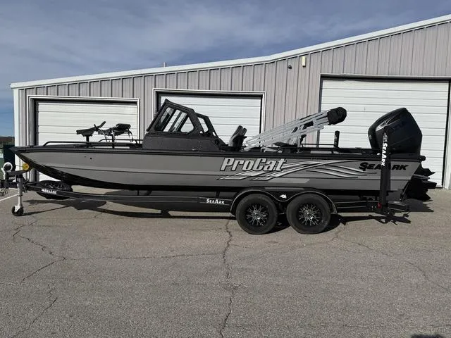 Slide: The Image of 2025 SeaArk Pro Cat 240 boat parked outside a garage. - 1