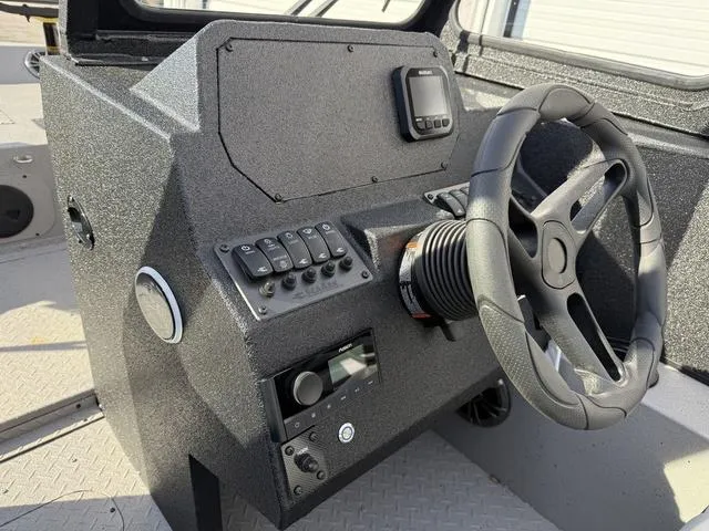 Slide: The Image of 2025 SeaArk Pro Cat 240 boat dashboard with steering wheel and control panel. - 14