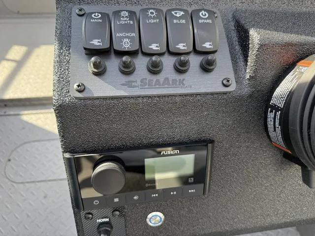 Slide: The Image of Control panel of 2025 SeaArk Pro Cat 240 boat with switches and Fusion audio system. - 15