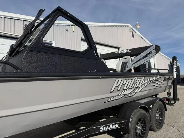 Slide: The Image of 2025 SeaArk Pro Cat 240 boat on trailer, parked outside a building. - 5