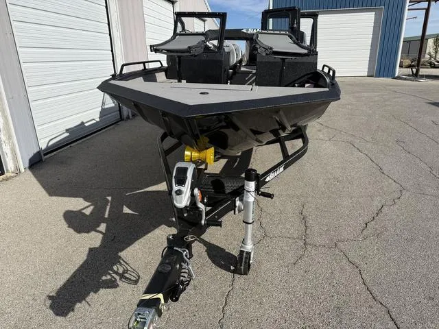 Slide: The Image of 2025 SeaArk Pro Cat 240 boat on trailer, parked outside storage units. - 6