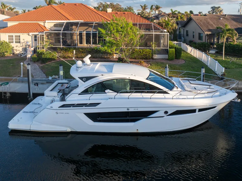 Slide: The Image of 2018 Cruisers Yachts 50 Cantius docked by waterfront homes. - 2