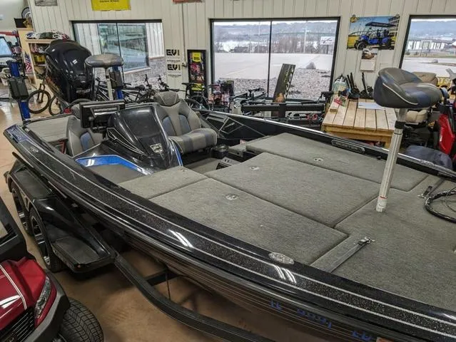 Slide: The Image of 2018 Skeeter FX20 bass boat in showroom, featuring spacious deck and seating. - 4