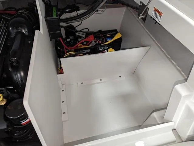Slide: The Image of 2023 Crownline 240 SS boat engine compartment with battery and wiring. - 10