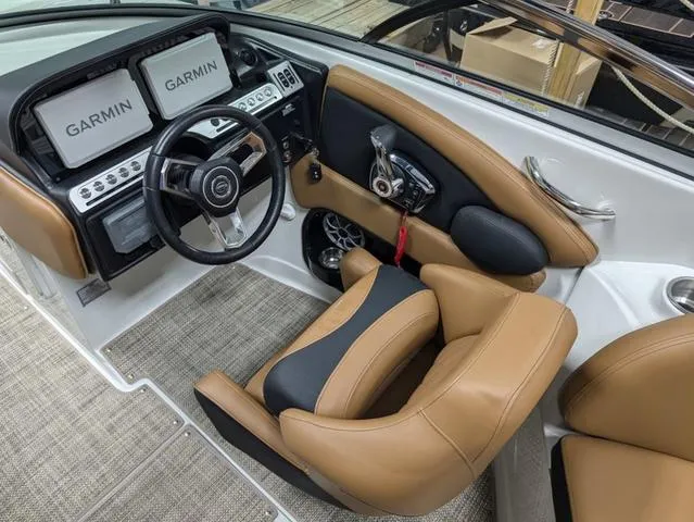 Slide: The Image of 2024 Crownline 290 SS boat cockpit with Garmin displays and tan leather seating. - 10