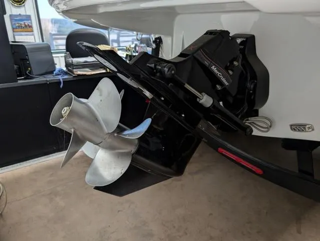 Slide: The Image of 2024 Crownline 290 SS boat with MerCruiser outdrive and propeller in showroom. - 12