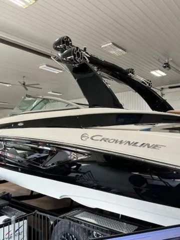 Slide: The Image of 2024 Crownline 290 SS boat in showroom, sleek design with black and white finish. - 6