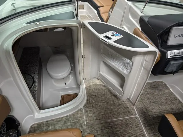 Slide: The Image of 2024 Crownline 290 SS boat interior with open bathroom door, showcasing modern amenities. - 9