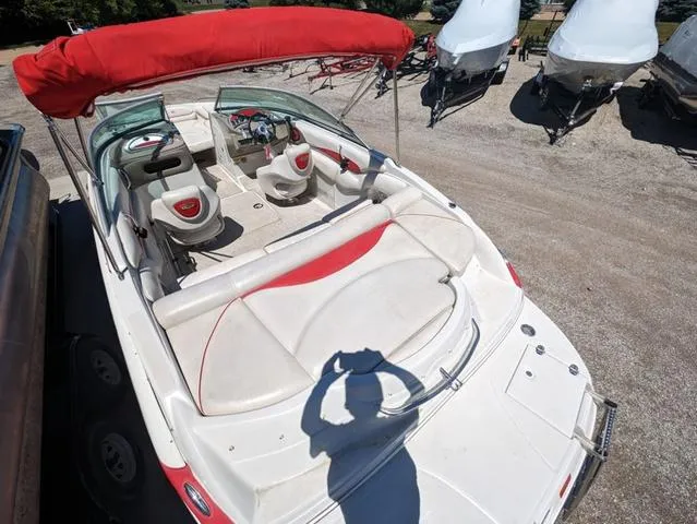 Slide: The Image of 2006 Crownline 220 LS boat with red canopy, parked on gravel lot. - 6