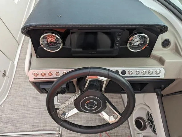 Slide: The Image of 2022 Crownline E235 XS boat dashboard with steering wheel and control panel. - 10