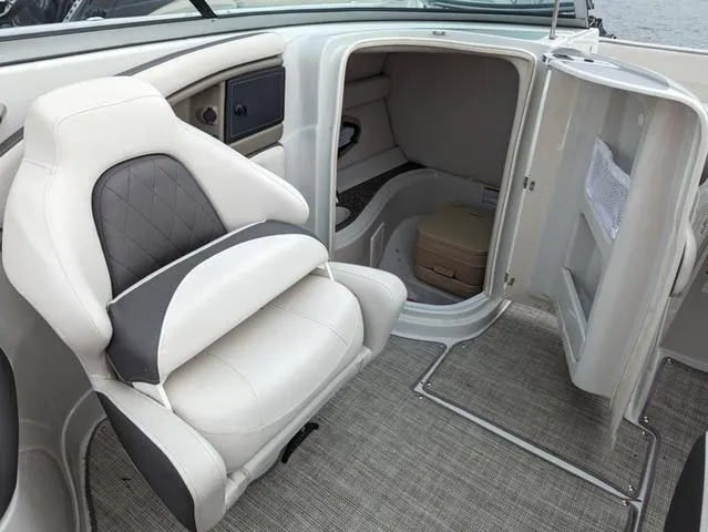 Slide: The Image of 2022 Crownline E235 XS boat interior with seating and storage compartment. - 11