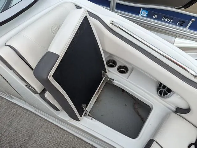 Slide: The Image of 2022 Crownline E235 XS boat seat storage compartment with cup holders and speaker. - 12