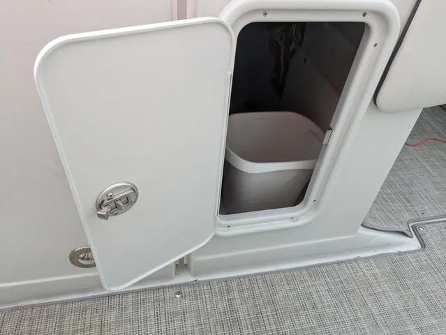 Slide: The Image of 2022 Crownline E235 XS boat storage compartment with open door. - 15
