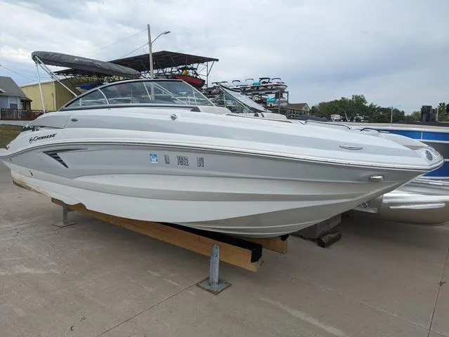 Slide: The Image of 2022 Crownline E235 XS boat on display, sleek white design, parked on a concrete surface. - 21