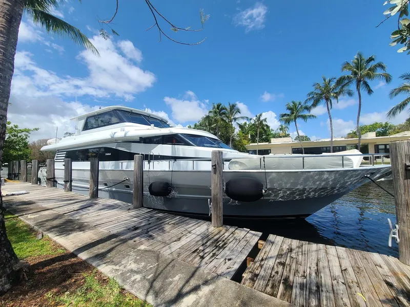Slide: The Image of Tarrab 1999 motoryacht docked by palm trees under a clear blue sky. - 2