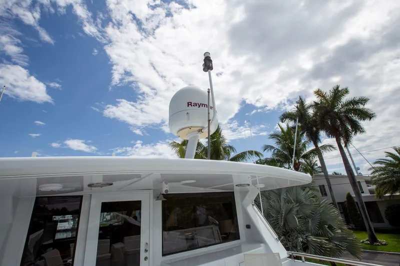 Slide: The Image of Tarrab 1999 motoryacht with radar, palm trees, and cloudy sky background. - 30