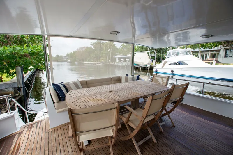 Slide: The Image of Spacious deck of 1999 Tarrab Motoryacht with wooden table and chairs, overlooking serene waterway. - 31