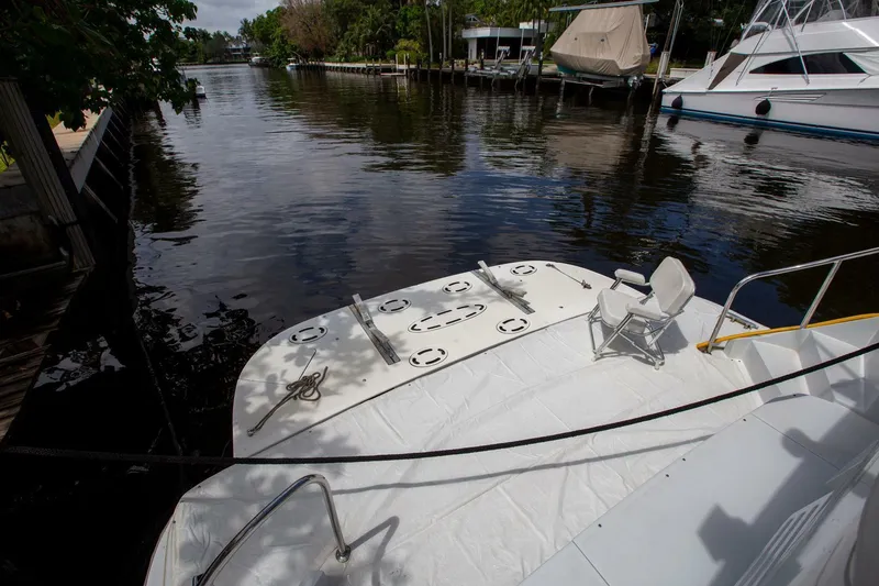 Slide: The Image of Tarrab 1999 motoryacht docked by a calm river with lush greenery. - 34