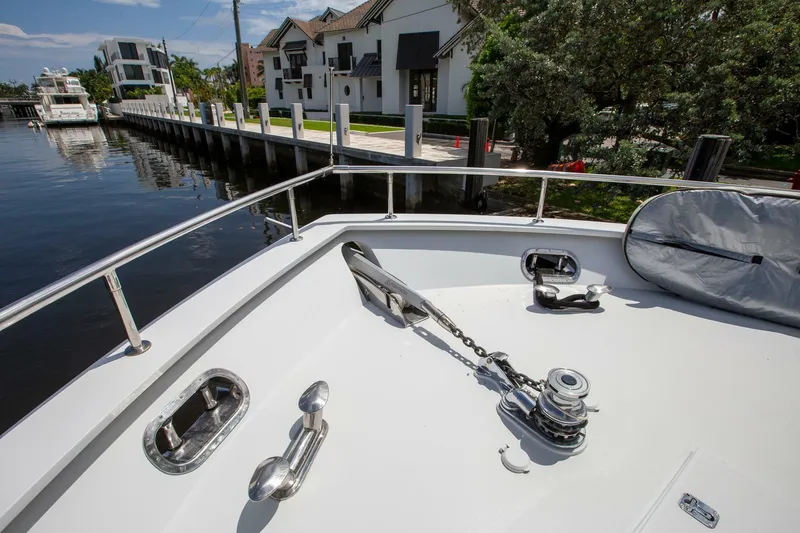 Slide: The Image of Tarrab Motoryacht 1999 anchored near waterfront homes, showcasing deck and anchor details. - 37