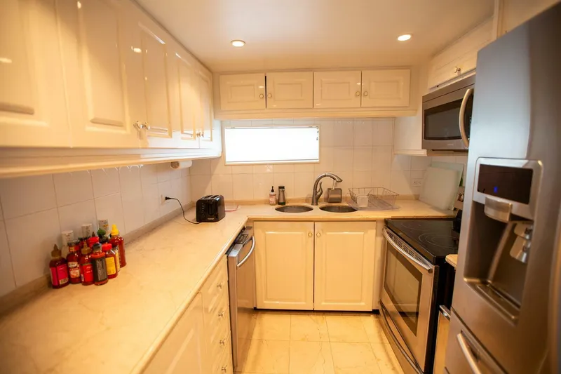 Slide: The Image of Luxurious kitchen in 1999 Tarrab Motoryacht with modern appliances and sleek white cabinetry. - 48