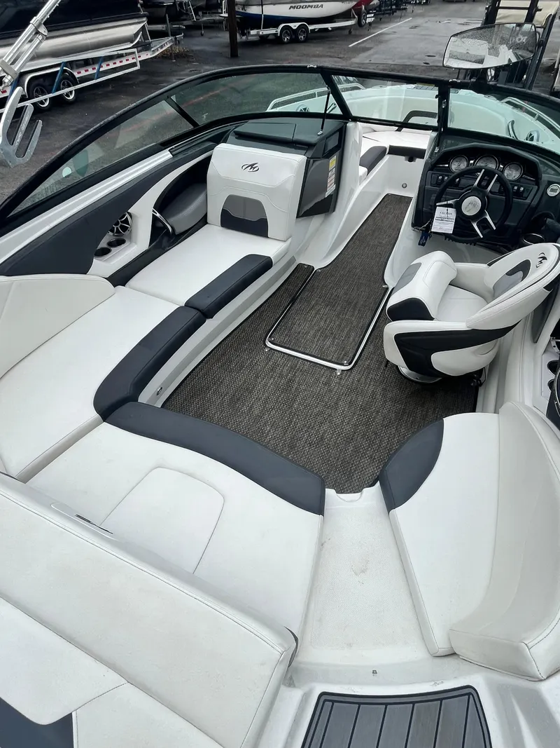 Slide: The Image of 2017 Monterey 224FS boat interior with white and gray seating, steering wheel, and dashboard. - 6