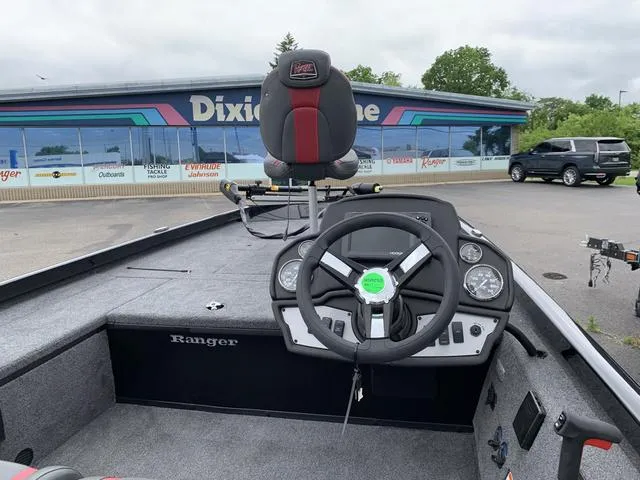 Slide: The Image of 2024 Ranger RT178C boat interior with steering wheel and seat, parked near Dixie Marine. - 3