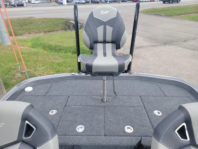 Slide: The Image of 2025 Ranger Z520R Ranger Cup boat with gray seating and deck, parked outdoors. - 11