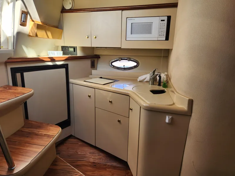 Slide: The Image of 1999 Cruisers Yachts 3375 Esprit kitchen with microwave, sink, and wooden steps. - 20