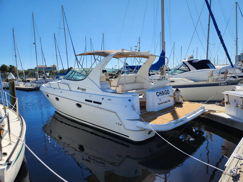 Slide: The Image of 1999 Cruisers Yachts 3375 Esprit docked in a marina, surrounded by sailboats. - 3
