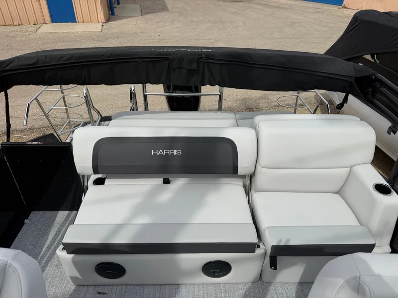 Slide: The Image of 2025 Harris Cruiser 210 pontoon boat with white seating and black canopy. - 11
