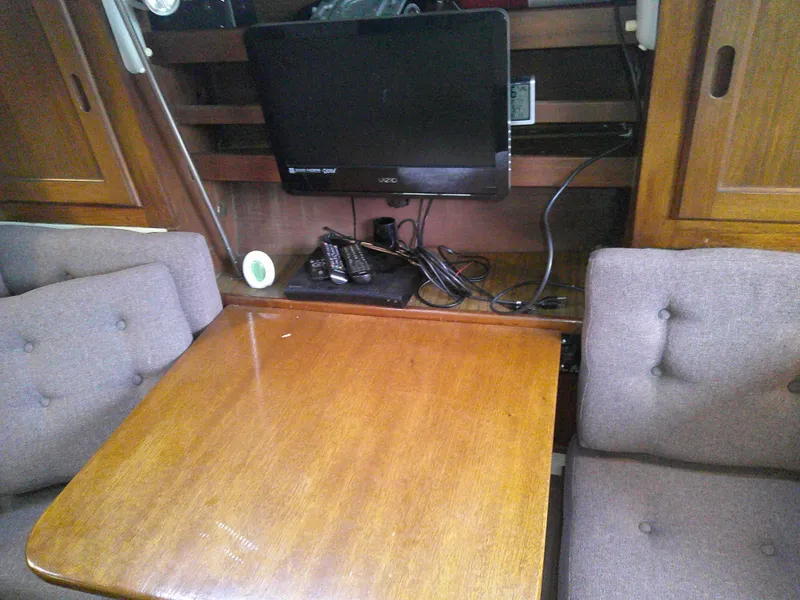 Slide: The Image of Interior of 1984 Catalina 36' sloop with wooden table, TV, and cushioned seating. - 7