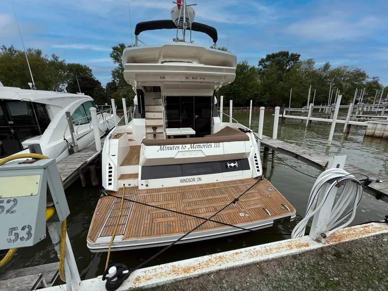 Slide: The Image of Galeon 560 Sky 2018 yacht docked at marina with wooden deck and serene surroundings. - 11