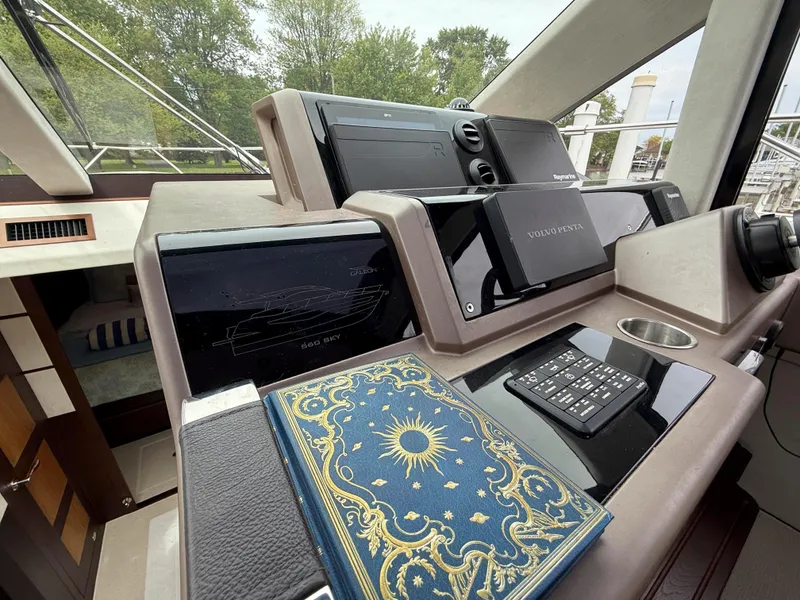 Slide: The Image of Control panel of 2018 Galeon 560 Sky yacht with navigation screens and decorative book. - 41